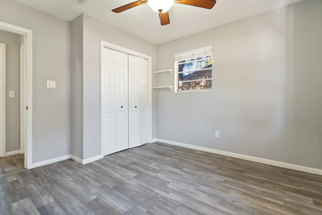 unfurnished bedroom with ceiling fan, a closet, and hardwood / wood-style floors