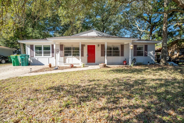 ranch-style house featuring covered porch and a front yard