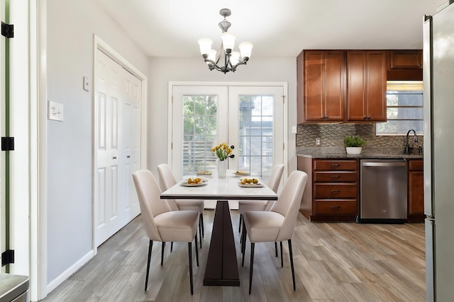 dining area featuring an inviting chandelier, light hardwood / wood-style flooring, and sink