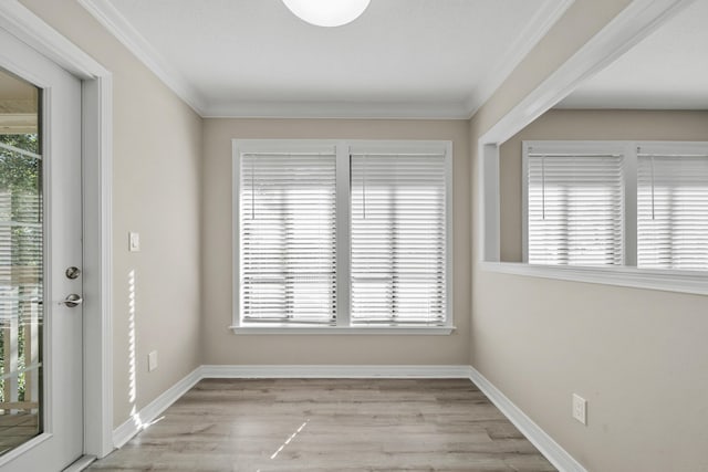 empty room with light hardwood / wood-style flooring and ornamental molding