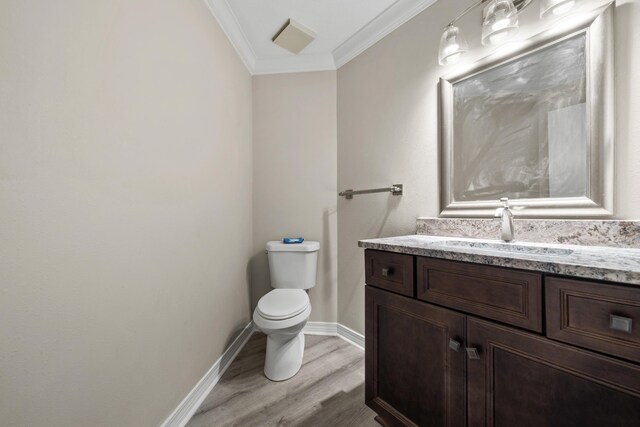 bathroom featuring hardwood / wood-style floors, vanity, toilet, and ornamental molding