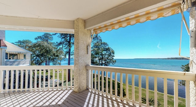 wooden deck with a water view and a beach view