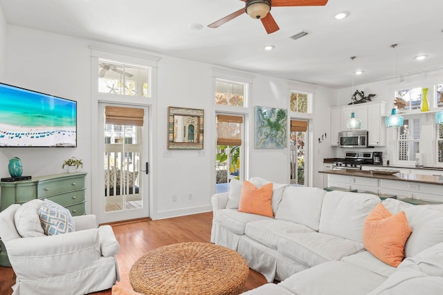 living room featuring light hardwood / wood-style flooring and ceiling fan