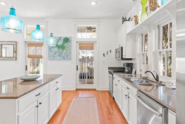 kitchen with pendant lighting, dark stone countertops, white cabinetry, and appliances with stainless steel finishes