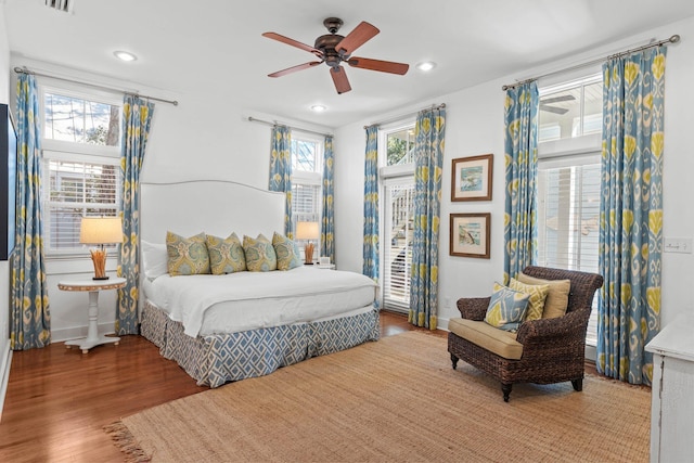 bedroom featuring multiple windows, ceiling fan, and wood-type flooring