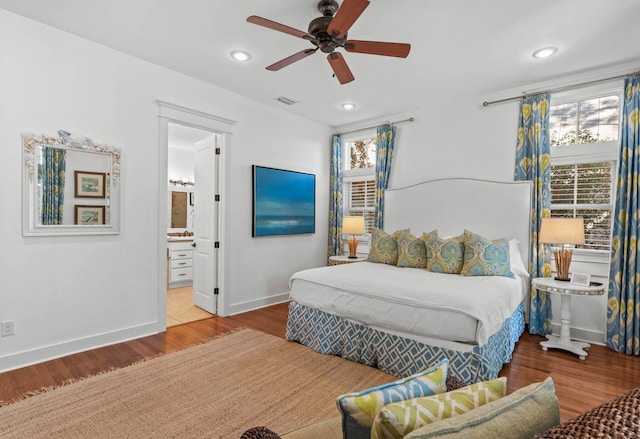 bedroom featuring hardwood / wood-style floors, ensuite bathroom, and ceiling fan