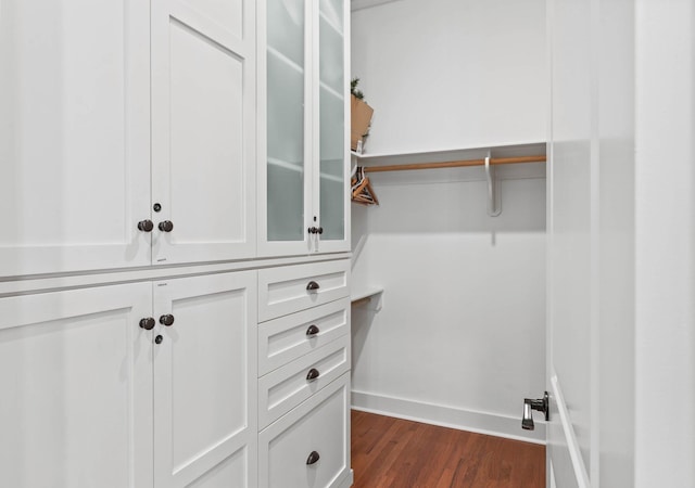 walk in closet with dark hardwood / wood-style flooring