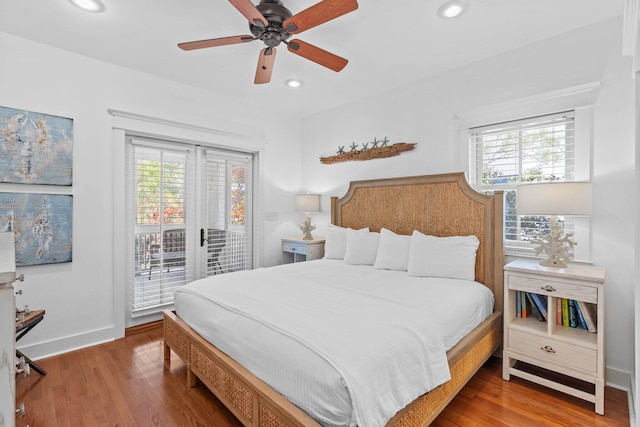 bedroom with multiple windows, wood-type flooring, access to outside, and ceiling fan