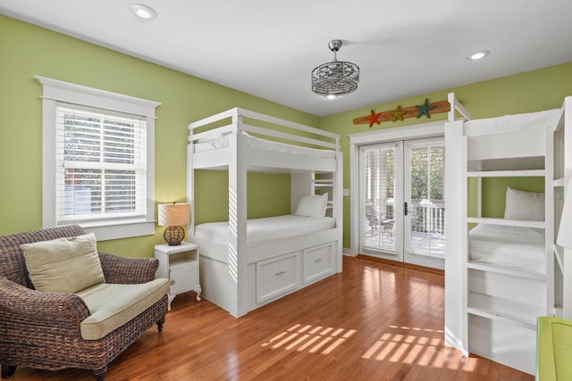 bedroom featuring access to exterior, hardwood / wood-style floors, french doors, and multiple windows