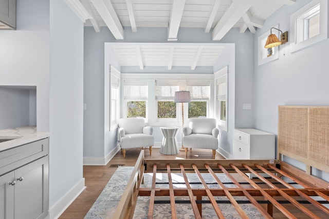 living area featuring hardwood / wood-style floors and beam ceiling