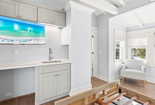 kitchen featuring gray cabinetry, wooden ceiling, sink, vaulted ceiling with beams, and light hardwood / wood-style floors