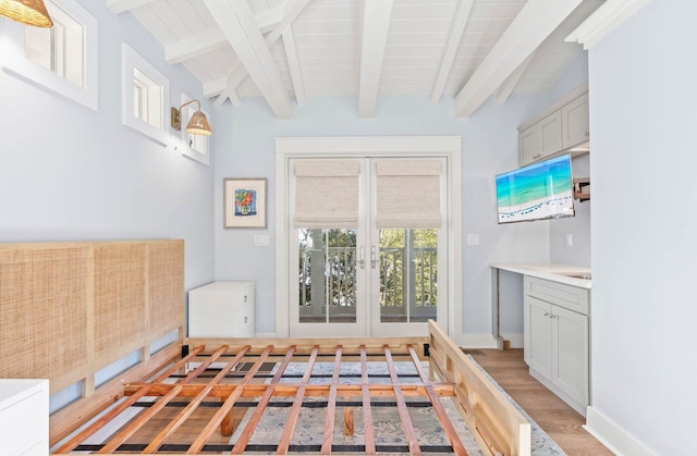 interior space featuring hardwood / wood-style floors, lofted ceiling with beams, and french doors