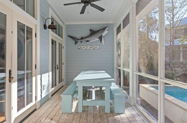 unfurnished sunroom with ceiling fan