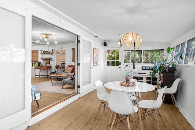 dining area featuring light hardwood / wood-style flooring and a notable chandelier