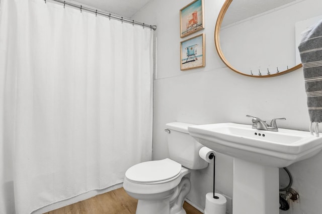 bathroom with hardwood / wood-style floors and toilet