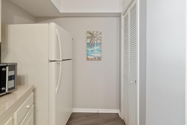 kitchen featuring hardwood / wood-style floors and white fridge