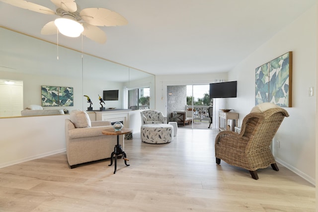 living room with ceiling fan and light hardwood / wood-style flooring