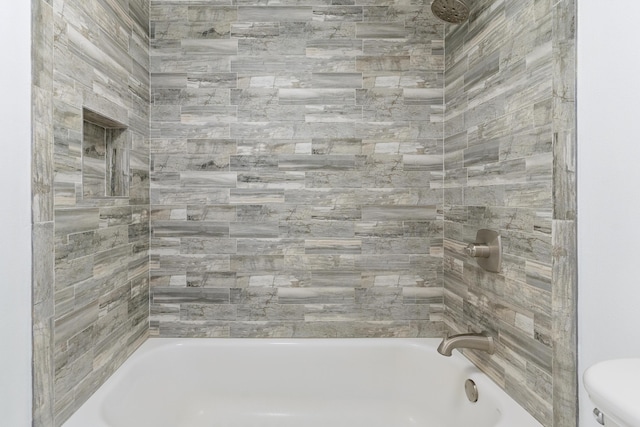 bathroom with tiled shower / bath and toilet