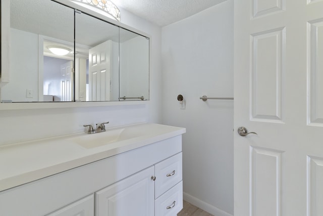 bathroom featuring a textured ceiling and vanity