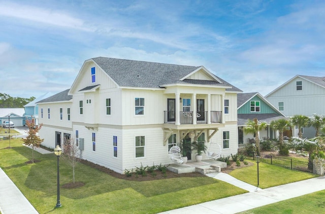 view of front of property with a front yard, a balcony, and covered porch