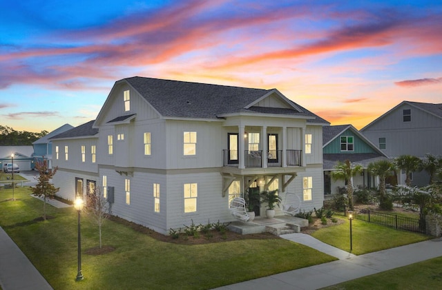 view of front of property featuring a yard and a balcony