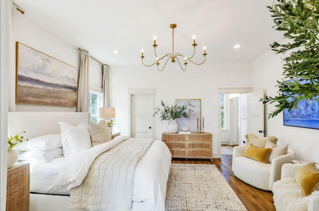 bedroom with dark wood-type flooring and an inviting chandelier