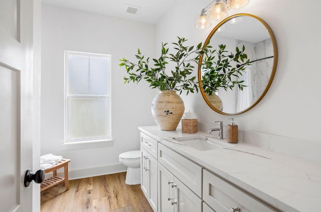 bathroom with hardwood / wood-style flooring, vanity, and toilet