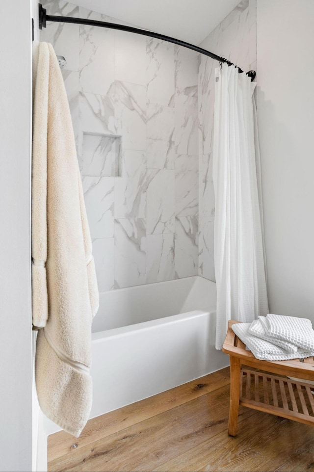 bathroom with shower / bath combination with curtain and wood-type flooring