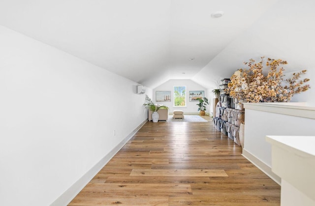 additional living space with lofted ceiling and hardwood / wood-style flooring