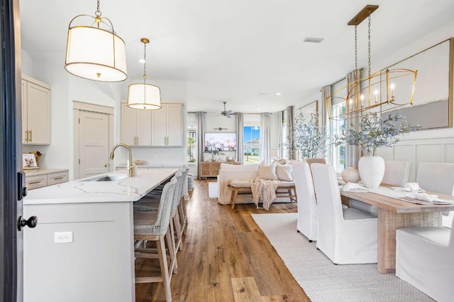 dining room with light hardwood / wood-style floors, ceiling fan, and sink