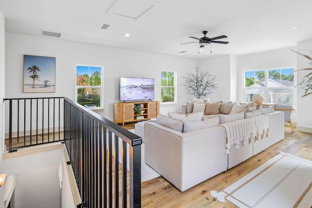 living room featuring light hardwood / wood-style flooring and ceiling fan