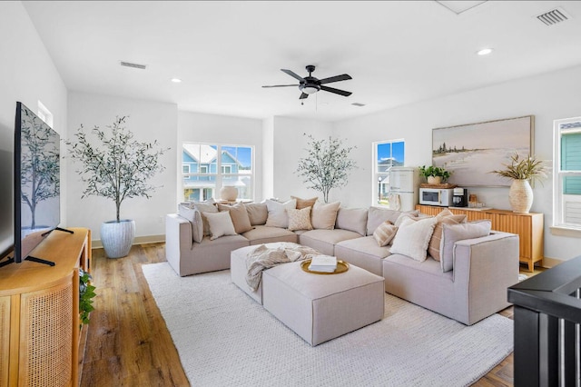 living room featuring wood-type flooring and ceiling fan