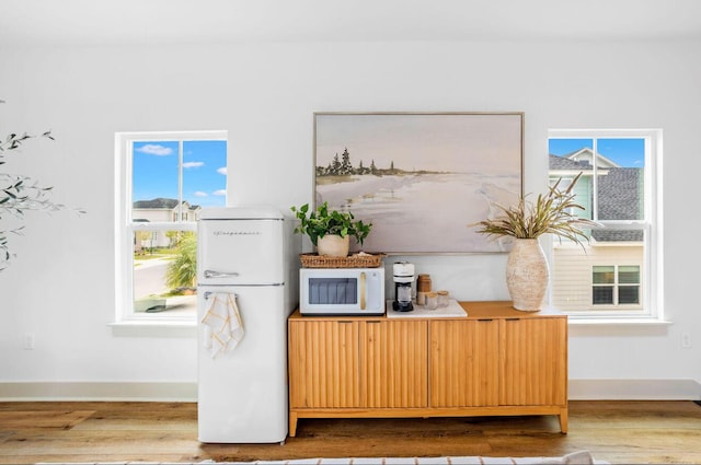 interior space featuring white appliances and hardwood / wood-style flooring