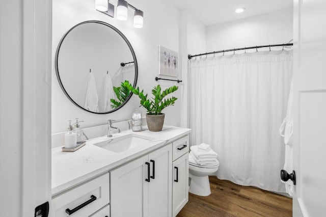 bathroom featuring vanity, hardwood / wood-style flooring, and toilet