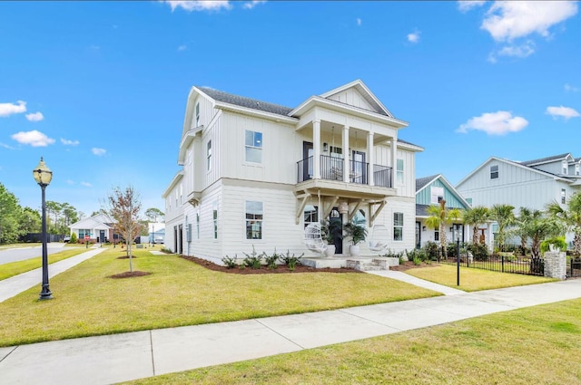 view of front facade featuring a balcony and a front yard