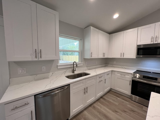 kitchen with stainless steel appliances, white cabinets, and sink