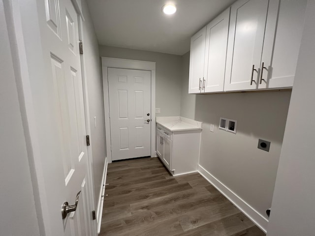 washroom featuring dark hardwood / wood-style flooring, electric dryer hookup, washer hookup, and cabinets