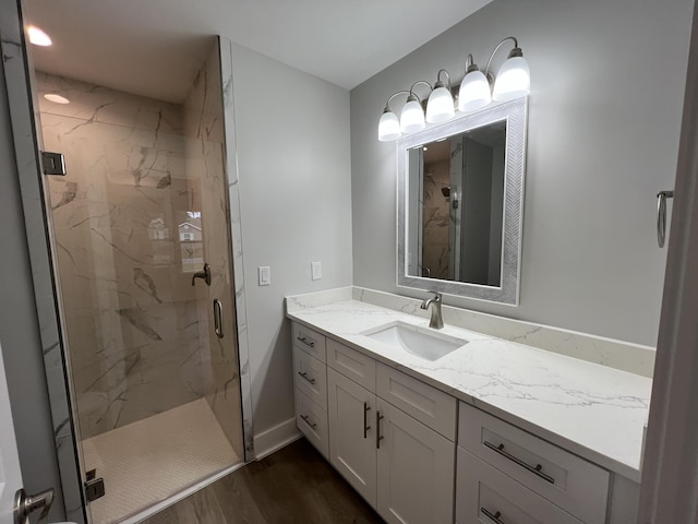 bathroom with a shower with door, vanity, and hardwood / wood-style floors