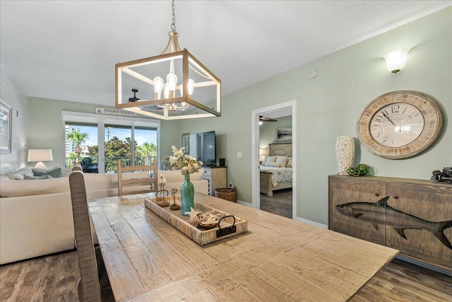 dining space featuring hardwood / wood-style floors and an inviting chandelier