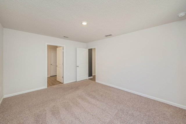 unfurnished bedroom with light carpet and a textured ceiling