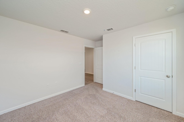 carpeted spare room with a textured ceiling