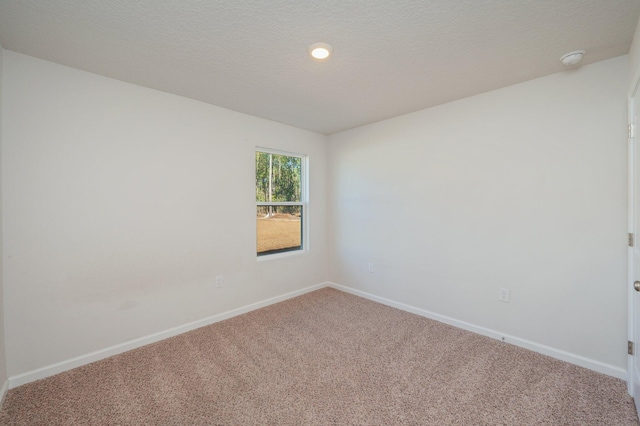 carpeted empty room with a textured ceiling