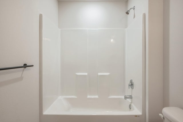 bathroom with washtub / shower combination and toilet