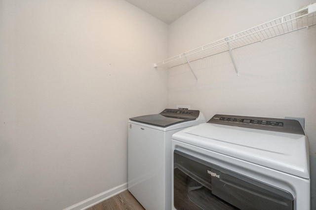 clothes washing area featuring independent washer and dryer and hardwood / wood-style flooring