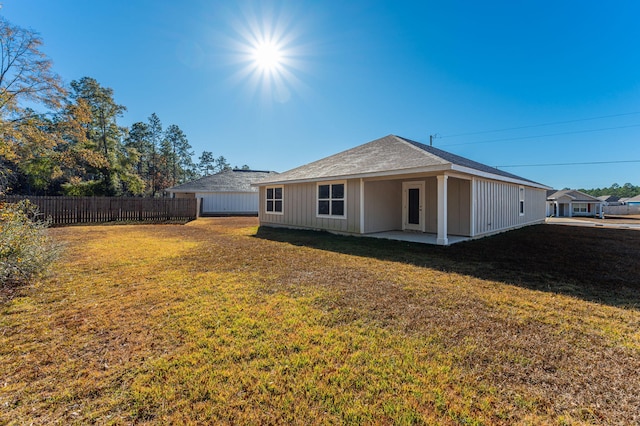 rear view of house featuring a yard and a patio