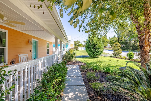 view of yard with ceiling fan and a porch