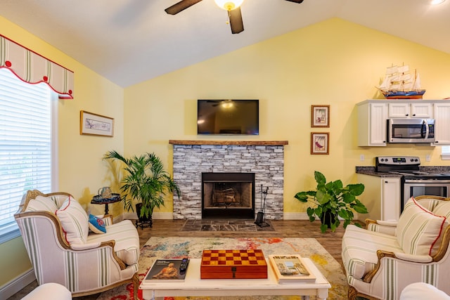 living room with a fireplace, hardwood / wood-style floors, vaulted ceiling, and ceiling fan