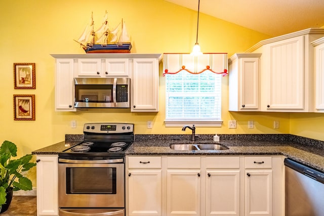 kitchen with appliances with stainless steel finishes, sink, white cabinets, hanging light fixtures, and lofted ceiling