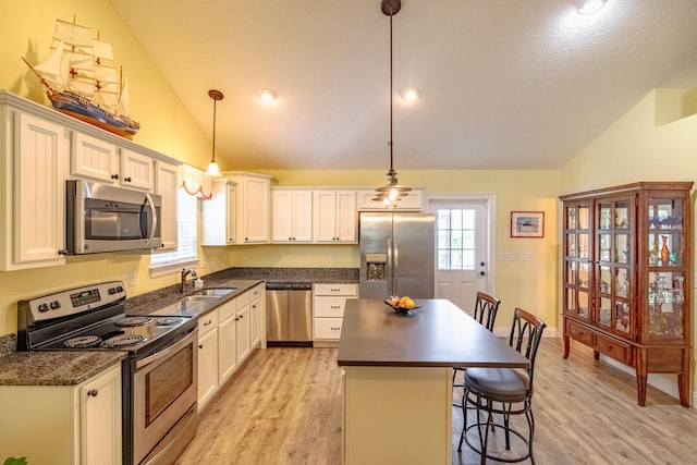 kitchen with white cabinets, pendant lighting, and stainless steel appliances