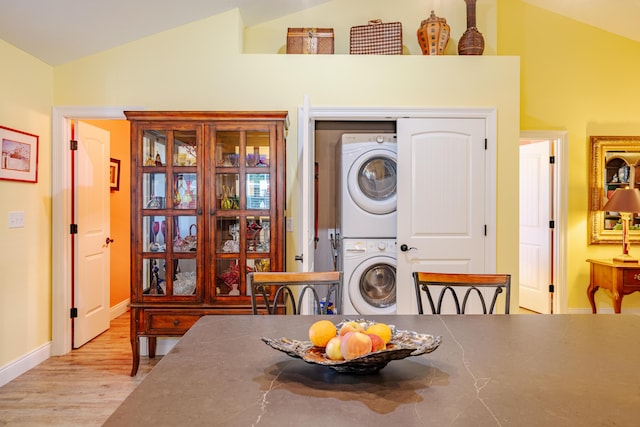 washroom featuring light hardwood / wood-style floors and stacked washer / drying machine